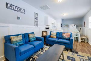 a living room with two blue couches and a table at 2 Mi to Barefoot Landing! Baileys Beach Cottage in Myrtle Beach