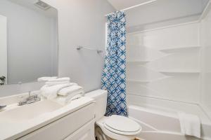 a white bathroom with a toilet and a shower at 2 Mi to Barefoot Landing! Baileys Beach Cottage in Myrtle Beach +23 photos