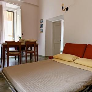 a bedroom with a bed and a dining room with a table at La Casetta Nelle Mura in Terracina