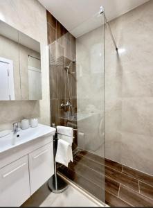 バールにあるStudio apartment, 5 minutes to the beachのガラスのシャワーと洗面台を備えたバスルーム