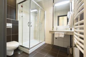
a bathroom with a shower, toilet and sink at Kopernikus Hotel Prag in Belgrade
