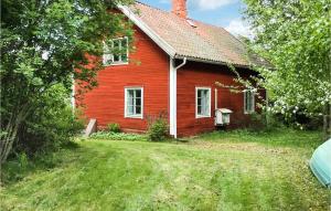 een oud rood huis met een tuin ervoor bij 3 Bedroom Nice Home In Norrtlje in Norrtälje