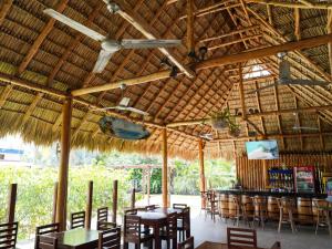 ein Restaurant mit Tischen und Stühlen und eine Bar in der Unterkunft Room to Roam in Rivas