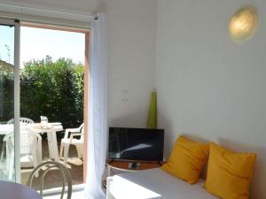un sofá blanco con almohadas amarillas en la sala de estar. en Maison Narbonne, 2 pièces, 4 personnes - FR-1-229B-39, en Narbona