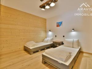 2 Betten in einem Zimmer mit Holzwänden in der Unterkunft Appartement Le Grand-Bornand, 3 pièces, 4 personnes - FR-1-391-118 in Le Grand-Bornand