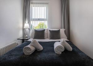 a bedroom with a large bed with towels on it at Comfy 3Bed House-Parking-Garden in Newcastle upon Tyne