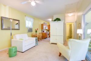 a living room with two white chairs and a table at Sunny Wells Cottage - 1 Mi to Moody Beach! in Wells +23 photos