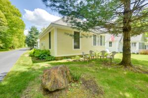 a yellow house with a rock in the yard at Sunny Wells Cottage - 1 Mi to Moody Beach! in Wells