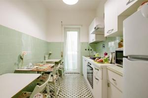 ローマにあるエコ B ＆ B マレラの白いキャビネットと黒と白のタイルフロアのキッチン