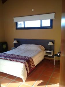 Un dormitorio con una cama grande con ventana. en HolaViajerosVGB, en Villa General Belgrano 43 fotos más