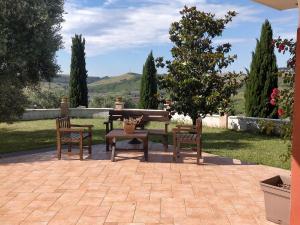 un patio con un tavolo, 2 sedie e un albero di Sunny Hill's Home a Monterotondo