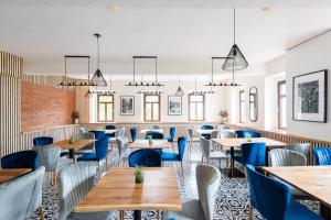 un restaurante con mesas de madera y sillas azules en Penzion Mezi buky en Chřibská