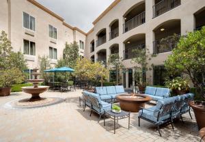 a courtyard with chairs and a fountain in front of a building at Ayres Hotel & Spa Mission Viejo - Lake Forest in Mission Viejo