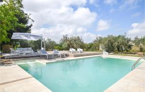 piscina con sedie e ombrellone di Awesome Home In Chiaramonte Gulfi With Wifi a Chiaramonte Gulfi