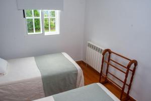 a bedroom with two beds and a window at Casa Rural Fidalgo in Chantada