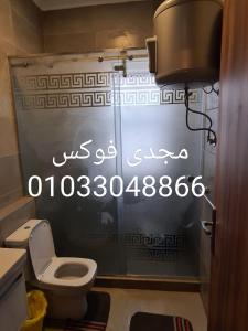 een badkamer met een toilet en een schrijftafel bij قريه امواج الساحل الشمالى in Abû Zeira