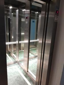 uma fila de portas de elevador de metal num edifício em Antares Apartments em Campana