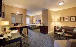 ミッションビエホにあるAyres Hotel & Spa Mission Viejo - Lake Forestのベッドとリビングルームが備わるホテルルームです。