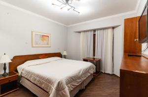 um quarto com uma cama e uma TV de tela plana em Flat 5 estrelas em Campos do Jordão em Campos de Jordão mais 47 fotografias