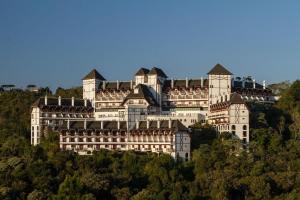 um grande edifício branco no topo de uma colina em Flat 5 estrelas em Campos do Jordão em Campos de Jordão
