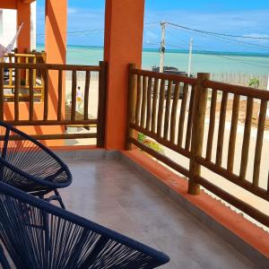 un banco sentado en un balcón con vistas a la playa en Casa Gostoso Mar, en São Miguel do Gostoso