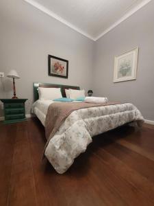 um quarto com uma cama grande e uma saia de cama. em Casa Villa Constanza em Itaipava