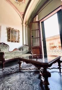 una camera con divano, tavolo e finestra di Super attico della Brigata Spendereccia! a Monteroni dʼArbia