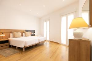 Dormitorio blanco con cama y lámpara en La Terracita de Bisagra, en Toledo