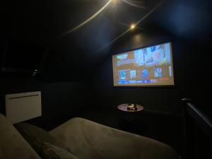 a room with a tv in a dark room at CASA DOLCE in Amiens