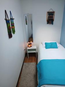 Habitación pequeña con 2 camas y espejo. en Departamentos Egaña, en Puerto Montt