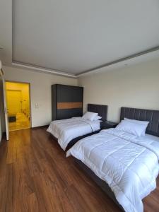 2 Betten in einem großen Zimmer mit Holzböden in der Unterkunft Luxurious & Charming Villa in Sheikh Zayed