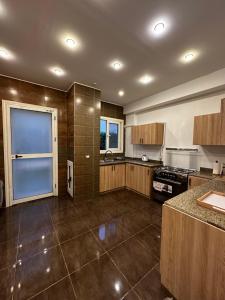 cocina grande con armarios de madera y ventana en Luxurious & Charming Villa, en Sheikh Zayed