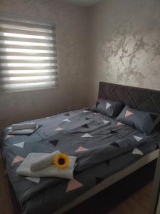 um quarto com uma cama com uma flor em Grand apartman em Belgrado