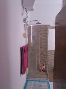 een douche in de badkamer met een rode handdoek bij Casa de Nômades Digitais in Mindelo