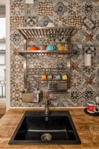 a kitchen with a sink and a wall with tiles at Luxury Flat by Central Station / Unique View in Milan