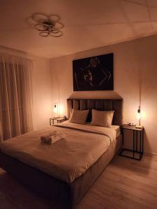 ChiajnaにあるElite Studio Militari Residenceのベッドルーム1室(大型ベッド1台、テーブル2台、ランプ2つ付)