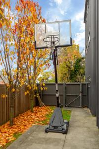 a basketball hoop in a yard with autumn leaves at Luxurious Christchurch Suite - Single Level 2 bed in Christchurch