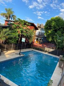 una gran piscina azul frente a un edificio en Hotel Yvy Pyta en San Ignacio