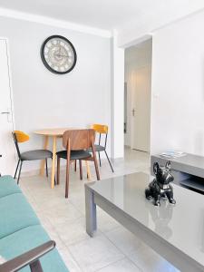 - un salon avec une table et une horloge murale dans l'établissement 2 bedroom luxury flat with Balcony Cannes Center, à Cannes