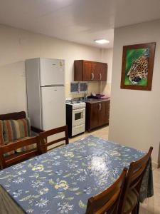 a kitchen with a dining table and a refrigerator at Hotel Yvy Pyta in San Ignacio