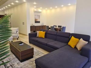 a living room with a blue couch and yellow pillows at Luxurious & Charming Villa in Sheikh Zayed