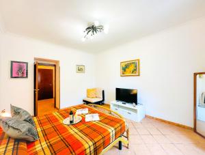 - un salon avec un lit et une télévision à écran plat dans l'établissement Giardino degli Aranci Lulus Home, à Rome