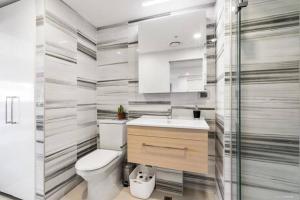 a bathroom with a toilet and a sink at Spacious one bedroom apartment in Newmarket in Auckland