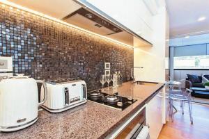 a kitchen with a counter top with a toaster and appliances at Spacious one bedroom apartment in Newmarket in Auckland