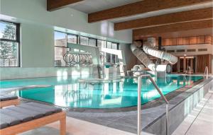 a swimming pool with a slide in a building at Stunning Home In Lembruch-dmmer See With 2 Bedrooms, Wifi And Indoor Swimming Pool in Lembruch