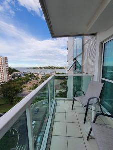 a balcony with a chair and a view of the water at Praia do canto-apart 703-vista mar in Vitória