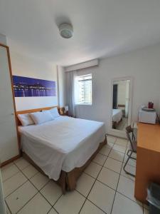 ein Schlafzimmer mit einem großen Bett und einem Fenster in der Unterkunft Praia do canto 502B in Vitória