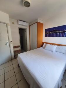 ein Schlafzimmer mit einem großen weißen Bett in einem Zimmer in der Unterkunft Praia do canto 502B in Vitória