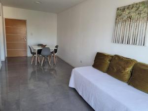 Schlafzimmer mit einem Bett und einem Tisch sowie einem Tisch und Stühlen in der Unterkunft Departamento céntrico villa ramallo in Ramallo