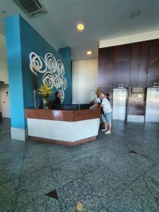 a woman standing at a counter in a lobby at Praia do canto-apart 703-vista mar in Vitória +20 photos